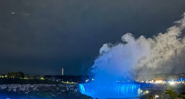 Vue des chutes du Niagara la nuit avec brume et lumières.
