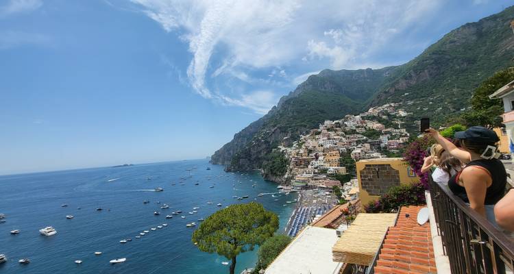 Vista costera con edificios coloridos y barcos en un día soleado.
