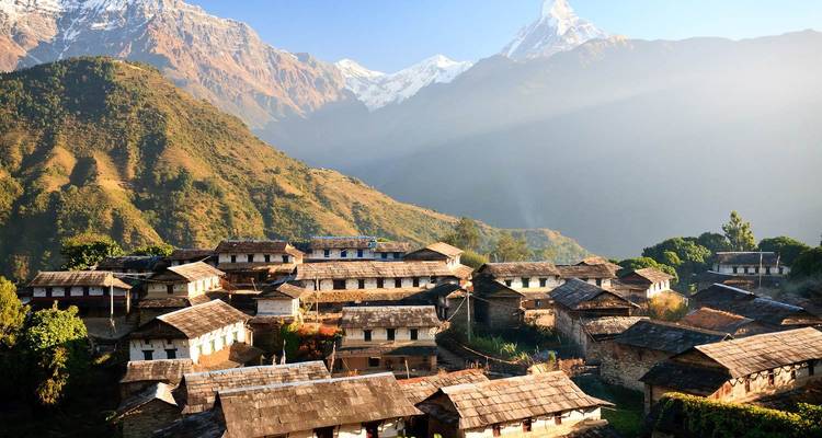 Traditioneel dorp met bergen op de achtergrond.