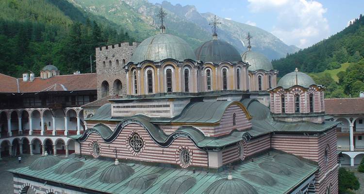 Une belle vue du monastère de Rila niché dans les montagnes, avec des détails architecturaux complexes et un arrière-plan pittoresque.