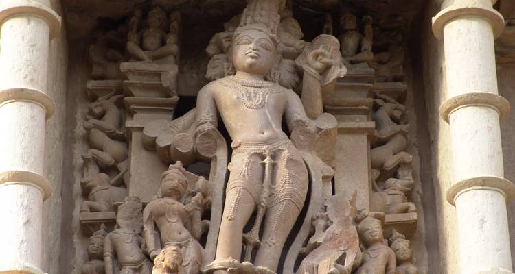 Intrincadas tallas de piedra de deidades en la fachada de un templo.