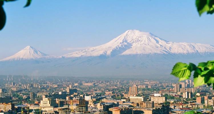 Vista panorámica de la ciudad de Ereván con el majestuoso monte Ararat cubierto de nieve alzándose imponente en el fondo.