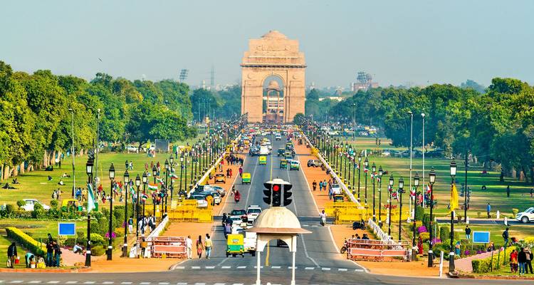 Puerta de la India con una carretera transitada y exuberantes jardines verdes.