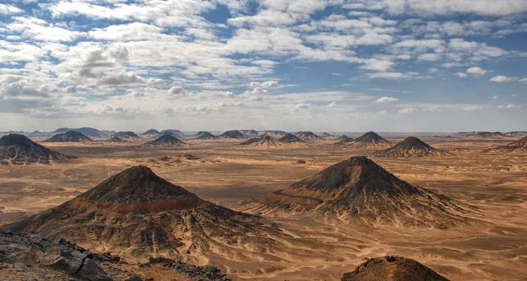 Vaste paysage désertique avec plusieurs pics montagneux.