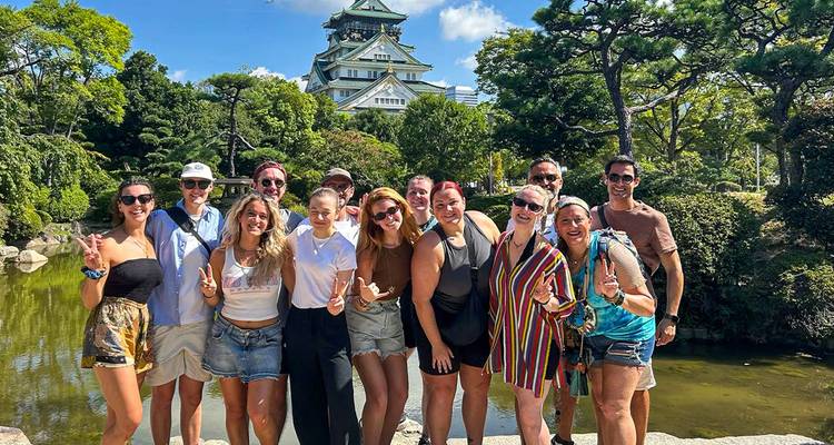 Groupe posant devant un château japonais.