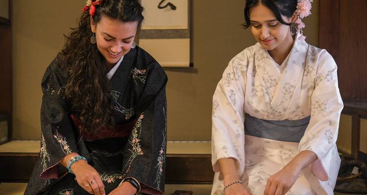 Deux femmes en tenue traditionnelle japonaise effectuant un rituel.