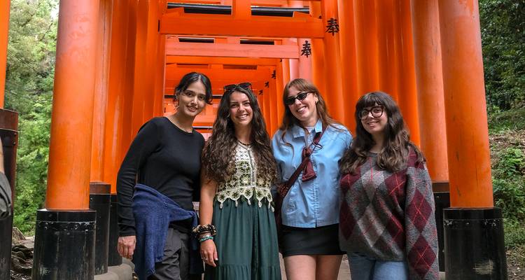 Quatre femmes posent devant des portails japonais traditionnels.