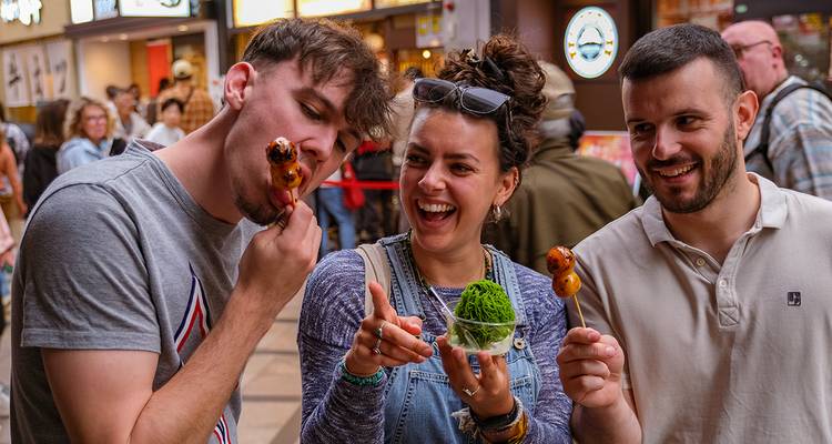 Groupe savourant de la nourriture de rue dans un marché animé.