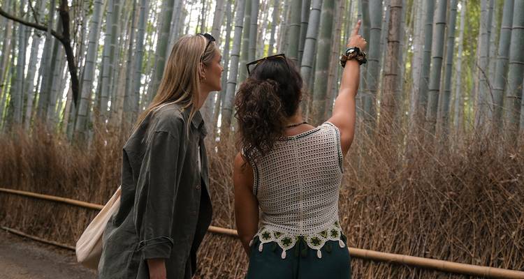 Deux femmes marchant à travers une forêt de bambous.