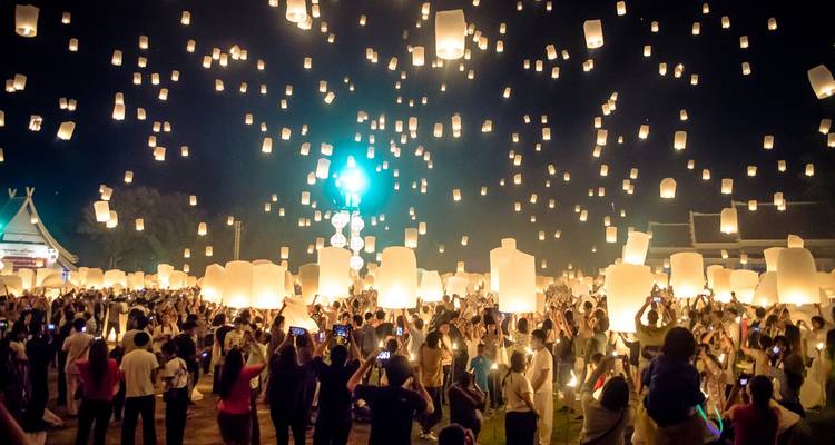 Miles de faroles de papel brillante se elevan hacia el cielo nocturno durante el festival Yi Peng de Chiang Mai mientras las multitudes celebran abajo.