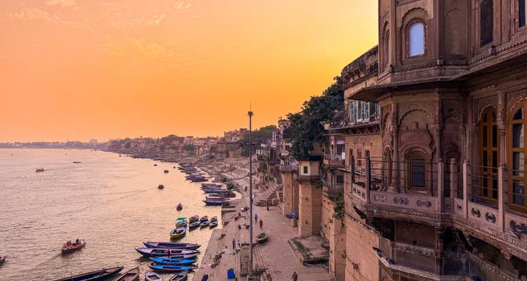 Une vue panoramique des ghats le long de la rivière au coucher du soleil.