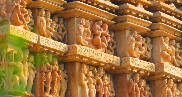 Tallados intrincados en la pared de un templo que muestran figuras y diseños.