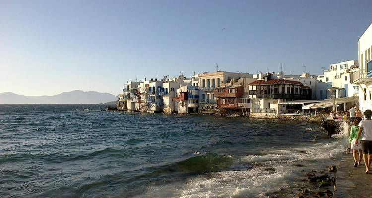 Vue sur l'océan des bâtiments de la Petite Venise, Mykonos, avec les vagues qui se brisent sur le rivage.