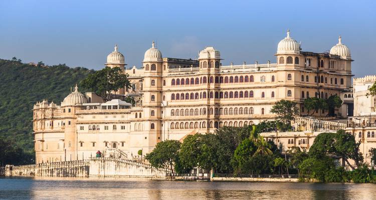 Vista del lago con el Palacio de la Ciudad en Udaipur con colinas al fondo.