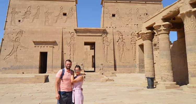 Pareja frente a un templo antiguo con tallados.