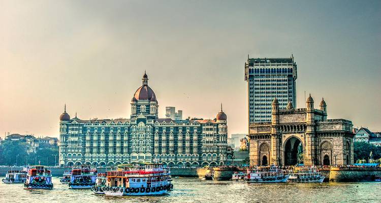 Ikonisches Hotel und Tor mit Booten auf dem Wasser in Mumbai.