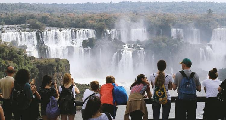 Turistas observando las Cataratas del Iguazú desde un mirador.