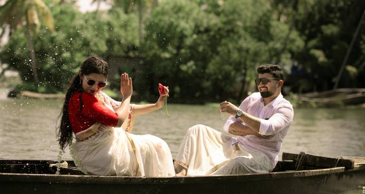 Een stel dat in een boot op een rivier zit, water opspattend en genietend van een moment.