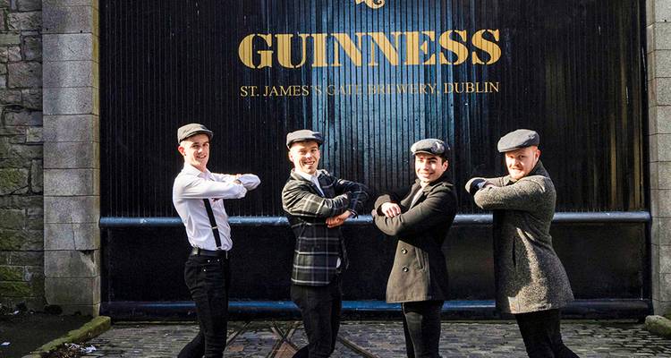 Vier mannen maken gechoreografeerde poses voor de poort van de Guinness-brouwerij in Dublin.