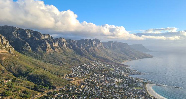 Vue panoramique de la côte et des montagnes avec des nuages et des eaux claires.