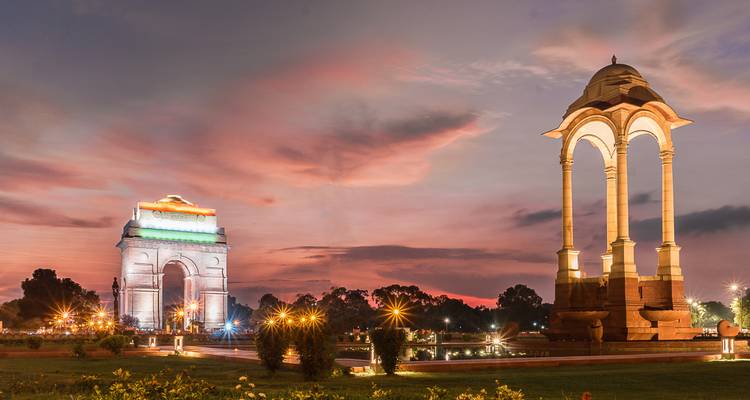 Das India Gate mit lebendigen Lichtern in der Abenddämmerung.