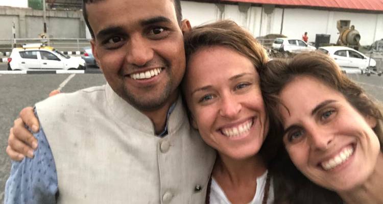 Gros plan de trois personnes souriantes dans un cadre extérieur.