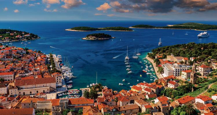 Panorama aérien spectaculaire de la ville de Hvar avec ses marinas, toits de terre cuite et îles adriatiques sous un ciel vibrant