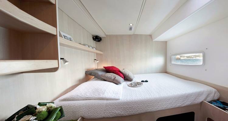 Cabine double lumineuse sur un catamaran avec fenêtre panoramique offrant vue sur mer et décor moderne