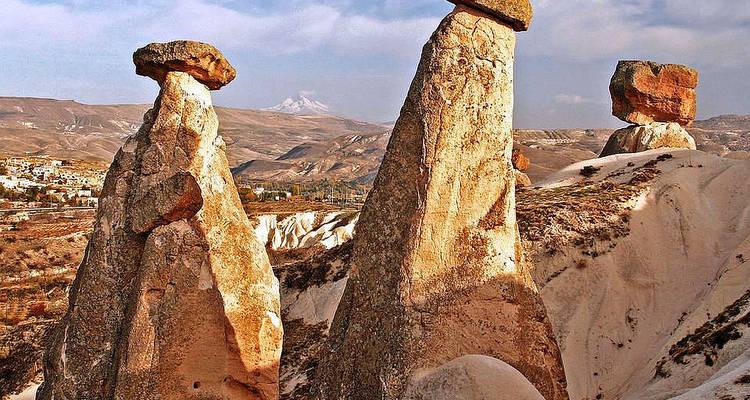 Formations rocheuses avec des montgolfières dans le ciel.