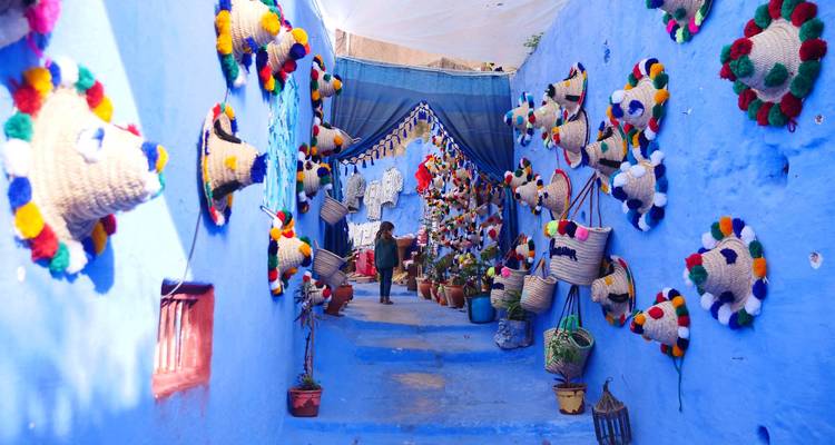 Dekorative blaue Straße mit lebendigen Kunsthandwerken und einer gehenden Person.