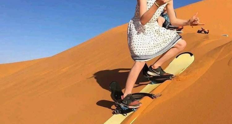 Personne faisant du sandboard sur une dune