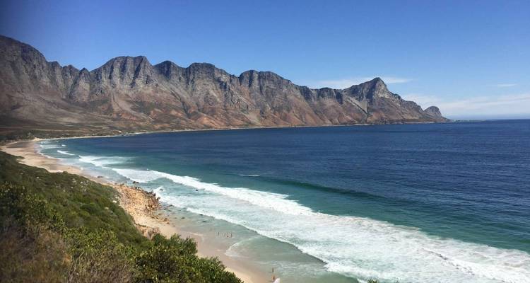 Vue panoramique côtière de l'océan turquoise rencontrant une chaîne de montagnes escarpées près du Cap.