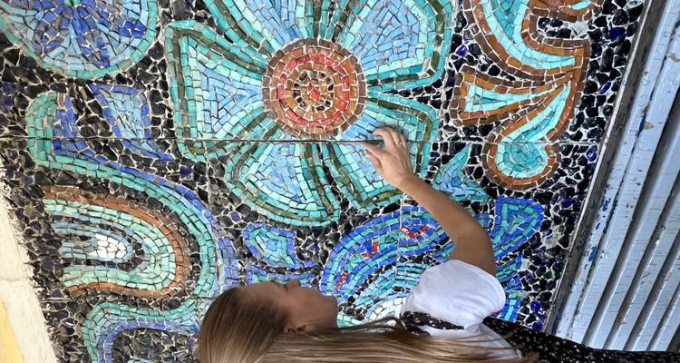 Femme observant une fresque colorée.