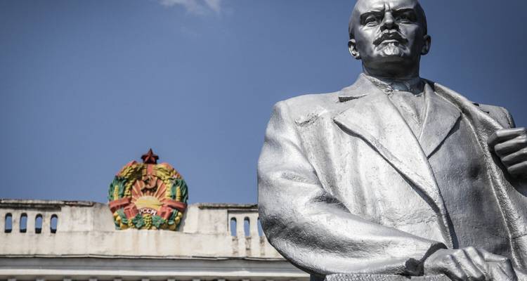 Statue de Lénine contre la façade d'un bâtiment.