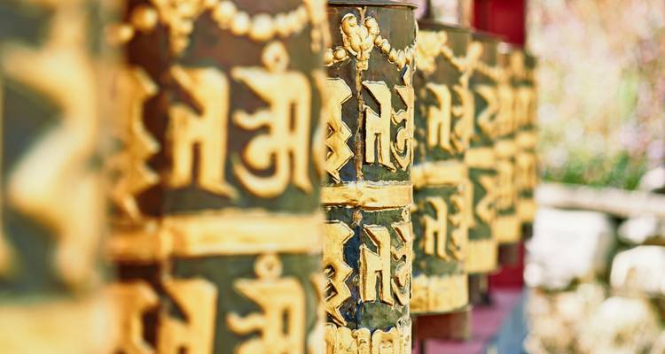 Nahaufnahme von goldenen Gebetsmühlen mit Inschriften in Bhutan