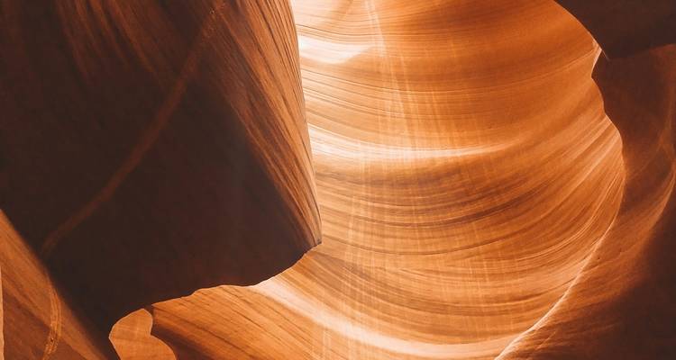 Faisceau étroit de lumière illuminant les parois lisses et sculptées d'un canyon.