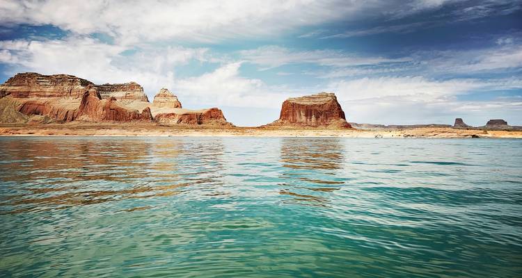 Eaux sereines du lac Powell reflétant les formations rocheuses rouges environnantes.