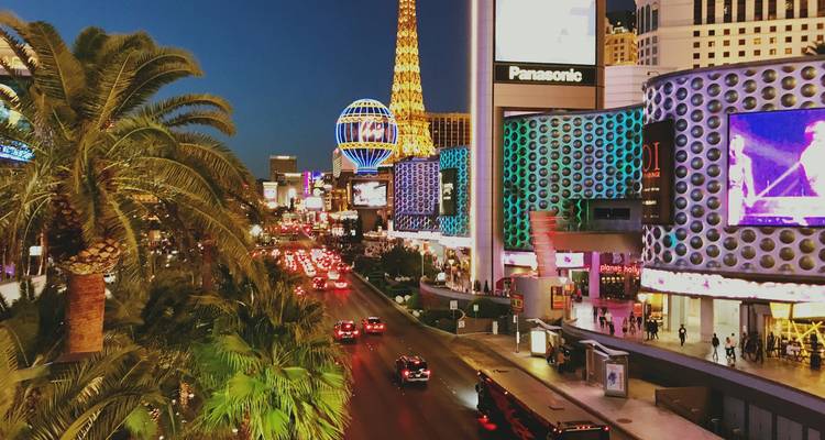 Le Strip de Las Vegas au crépuscule avec des lumières éclatantes et une circulation animée.