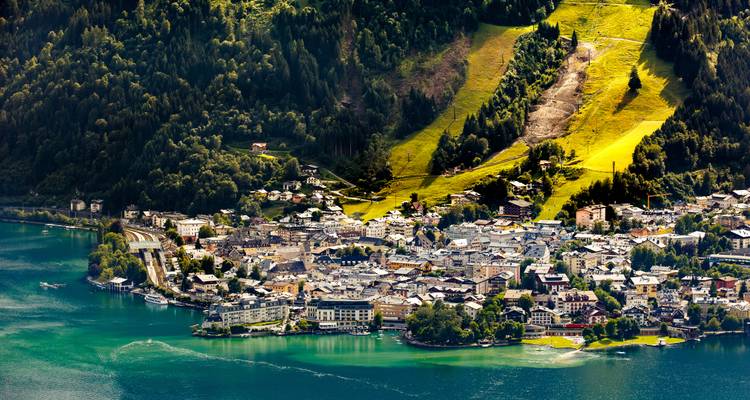 Vue aérienne de Zell am See avec des bâtiments colorés et un lac éclatant.