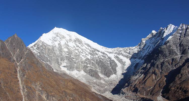 Vista de cerca de un pico montañoso cubierto de nieve bajo un cielo despejado.