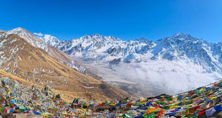 Paisaje montañoso con banderas de oración en primer plano.