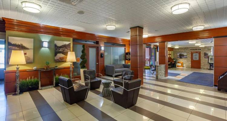 Vestíbulo de hotel con elementos de diseño moderno y área de descanso.