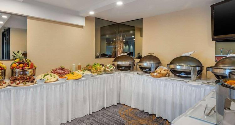 Buffetaufbau mit verschiedenen Gerichten und Servierplatten in einem Esszimmer.