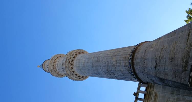 Un grand minaret contre un ciel bleu clair.