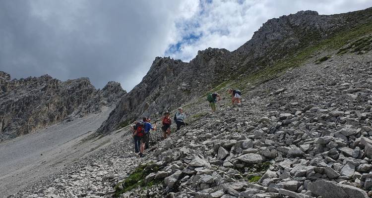 Des gens faisant de la randonnée sur une pente rocheuse.