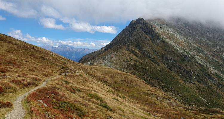 Une vue de montagne avec de l'herbe sèche et un ciel dégagé.