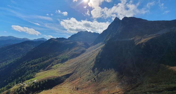 Un paysage de montagne avec des rayons de soleil et des nuages.