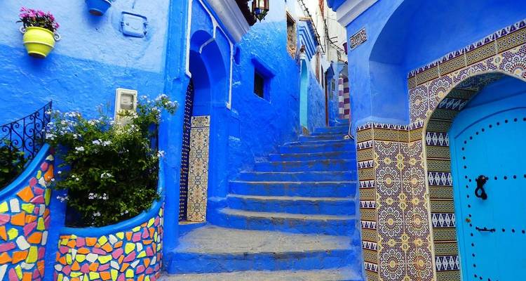 Blue-painted street with colorful ceramics in Chefchaouen.