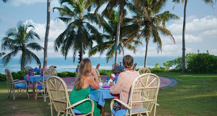 Femmes dînant en plein air avec vue sur l'océan.