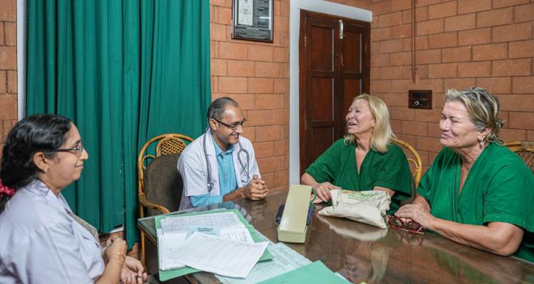 Quatre personnes assises autour d'une table, ayant une discussion.